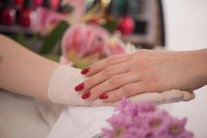 manos de mujer recibiendo una manicura foto