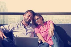 pareja relajándose en casa usando computadoras portátiles foto