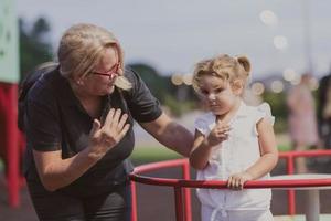 An older grandmother is playing with her grandson in the park at sunset. Selective focus photo