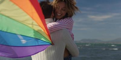 Happy couple having fun with kite on beach photo