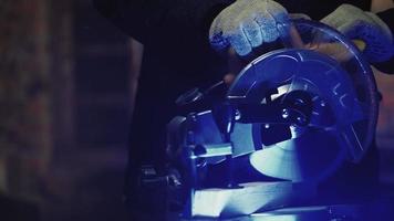 Worker Carpenter Sawing a Board with a Circular End Saw in his Carpentry Workshop. Woodworking Production. High quality 4k footage video