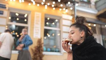 vrouw in een buitenshuis cafe eet een bevroren gebakje video