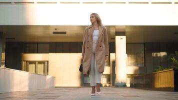 bellissimo attività commerciale donna passeggiate con fiducia attraverso il città parco a tramonto. carriera le persone. moda, bellezza. femmina ritratti. vero le persone. lento movimento video