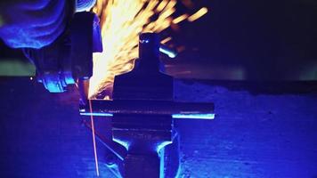 Professional mechanic cuts off metal pipe with a grinder, clamping them in a vise. Man works with circular saw. Disk that rotates and cuts metal close up. Steel industry and workshop concept. video