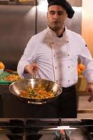 chef flipping vegetables in wok photo