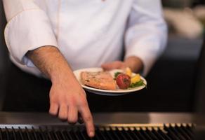 chef manos cocinando salmón a la parrilla foto