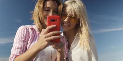 Two girl friends having fun photographing each other on vecation photo