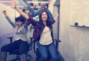 multiethnics business team racing on office chairs photo