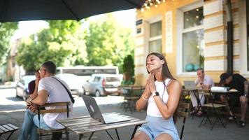 vrouw zit Bij buitenshuis cafe gebruik makend van laptop video