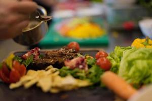 Chef finishing steak meat plate photo