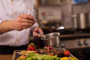 Chef finishing steak meat plate photo