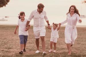 Senior couple in casual clothes with their children, boy and girl enjoy the beach spending a vacation together. Family time . Selective focus photo