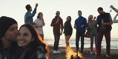 Friends having fun at beach on autumn day photo