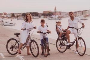 The happy family enjoys a beautiful morning by the sea riding a bike together and spending time together. The concept of a happy family photo