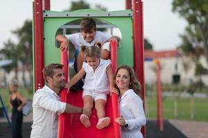 pareja mayor en ropa casual con sus hijos pasando tiempo en el parque de vacaciones juntos. tiempo familiar . enfoque selectivo foto