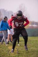 American football team exercises on ladder drills at field photo