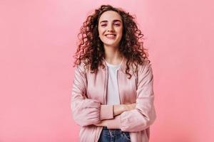 Beautiful girl in silk jacket smiling on pink background