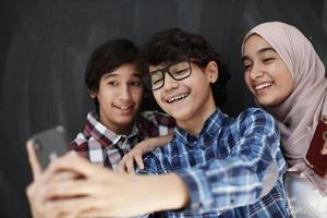 group of arab teens taking selfie photo on smart phone