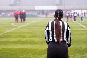 rear view of female american football referee photo