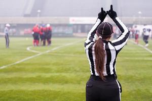 rear view of female american football referee photo