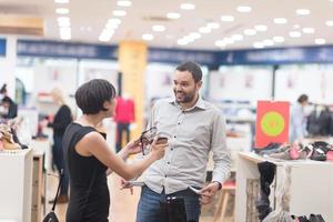 pareja elige zapatos en zapatería foto