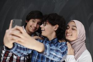 grupo de adolescentes árabes tomando una foto selfie en un teléfono inteligente