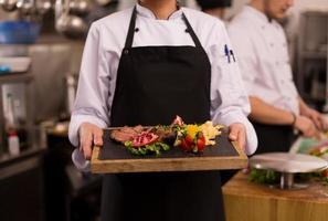 female Chef holding beef steak plate photo