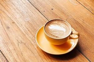 Top view of a latte art coffee on old wooden table. photo