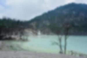 Blurred view of Kawah Putih, white crater, a hot volcanic lake. Tourist destination in South of Bandung, West Java, Indonesia. photo