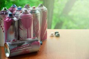 un montón de latas de aerosol usadas de primer plano de pintura. latas sucias y manchadas para dibujar graffiti. el concepto de un dibujo de pintura arrebatador y descuidado. imagen de arte creativo foto