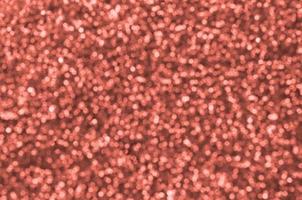 Blurred orange decorative sequins. Background image with shiny bokeh lights from small elements photo