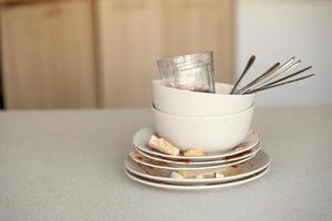 Stack of dirty dishes with food leftovers on the table after meal. Banquet ending concept. Unwashed dishes photo