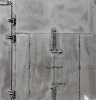 Black painted garage gates with door under the sunlight. Background texture or resource for 3d texturing photo