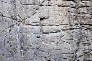 Light coarse natural rock stone background. Mining cliff rough front surface. Big limestone stack backdrop. Heavy grunge damaged granite block texture photo