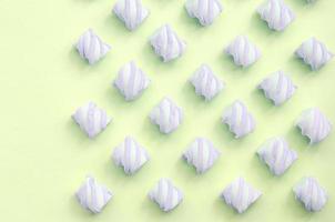 Colorful marshmallow laid out on lime paper background. pastel creative textures photo