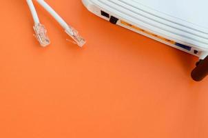 Internet router and Internet cable plugs lie on a bright orange background. Items required for Internet connection photo