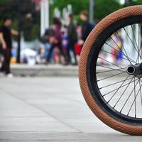 una rueda de bicicleta bmx con el telón de fondo de una calle borrosa con ciclistas. concepto de deportes extremos foto