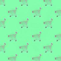 Shopping addiction, shopping lover or shopaholic concept. Many small empty shopping carts perform a pattern on a pastel colored paper background. Flat lay composition, top view photo