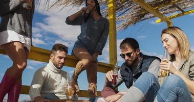 Group of friends having fun on autumn day at beach photo