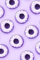 Many small plastic donuts lies on a pastel colorful background. Flat lay minimal pattern. Top view photo