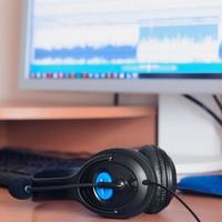 Big black headphones lie on the wooden desktop of the sound designer photo