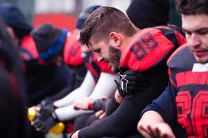 jugador de fútbol americano sosteniendo el hombro lesionado foto