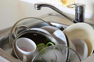 Dirty dishes and unwashed kitchen appliances filled the kitchen sink photo