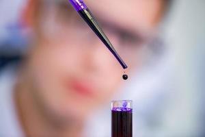 student with protective glasses making chemistry experiment photo