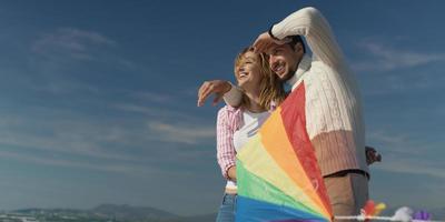 Happy couple having fun with kite on beach photo