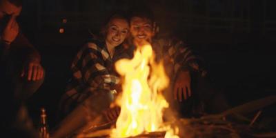 Couple enjoying with friends at night on the beach photo