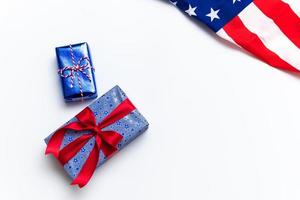 Happy Veterans Day concept. American flags with gift box against a blackboard background. November 11. photo