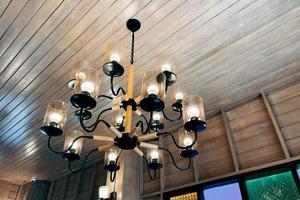 Old classic and antique chandelier on an old wooden ceiling interior design. photo