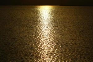 Sunrise on the shore of the Dead Sea in Israel. The sun rises from behind the mountains in Jordan. photo