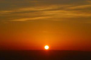 amanecer en la orilla del mar muerto en israel. el sol sale por detrás de las montañas en jordania. foto